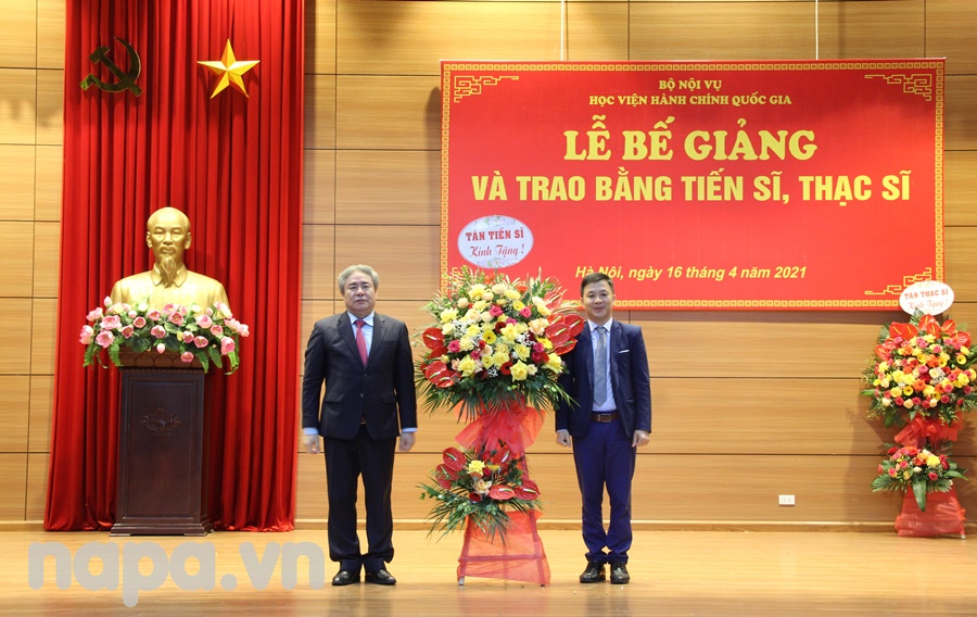 Mr. Truong Quoc Viet, on behalf of newly graduated doctors, presenting flowers to NAPA President, Dr. Dang Xuan Hoan 