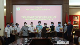 Leaders of Dong Da District, Lang Ha Ward, and Monk Thich Dai Thang presenting gifts to Lao students.
