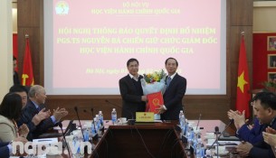 Vice Minister Trieu Van Cuong handing over the Decision and congratulating Assoc.Prof.Dr. Nguyen Ba Chien