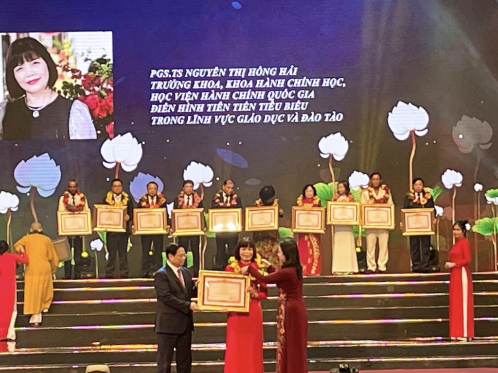 Prime Minister Pham Minh Chinh and Vice President Vo Thi Anh Xuan awarding a certificate of merit to Assoc.Prof.Dr. Nguyen Thi Hong Hai, Dean, Faculty of Administrative Sciences, National Academy of Public Administration