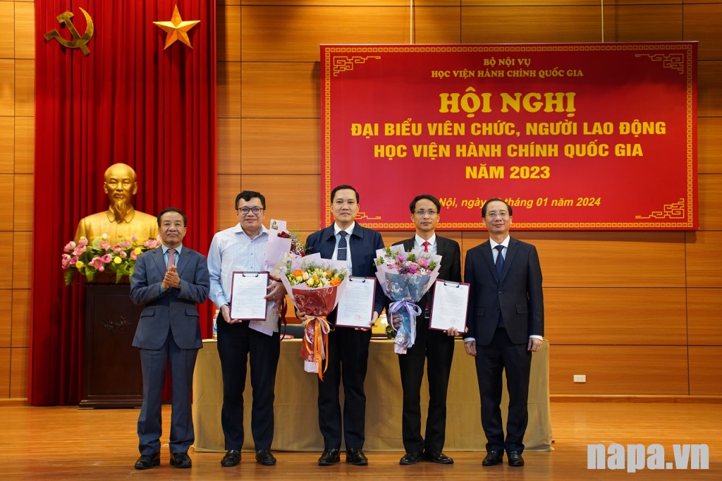 Assoc. Prof., Dr. Nguyen Ba Chien and Dr. Nguyen Dang Que handing over the Decision of associate professor appointment and gave flowers to Dr. Nguyen Nghi Thanh, Dr. Ngo Si Trung, and Dr. Phuong Huu Tung.