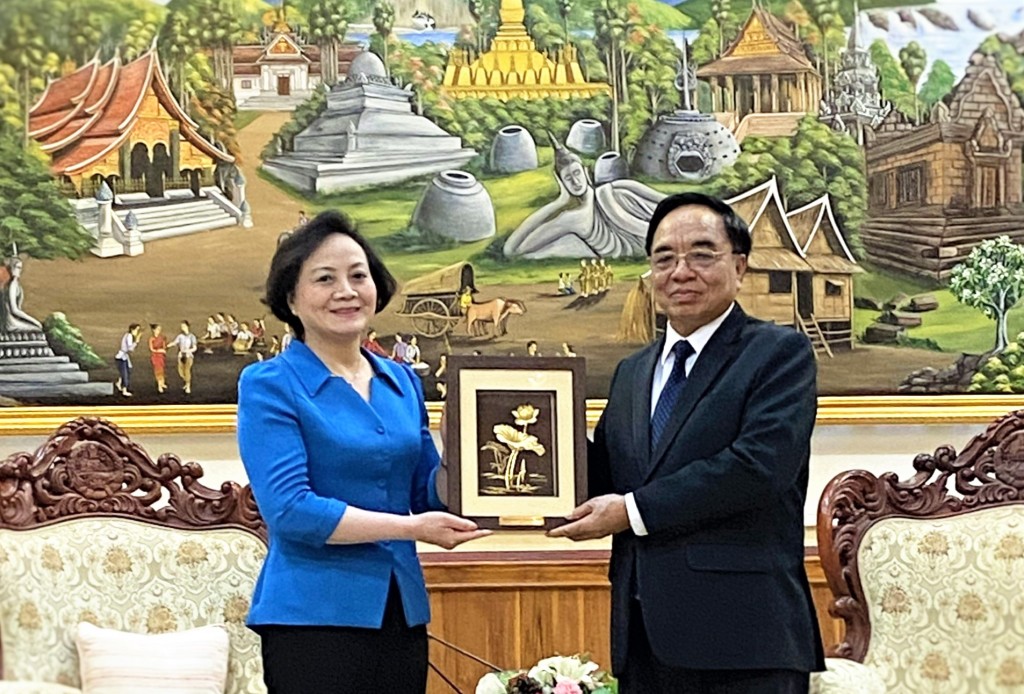 Minister of Home Affairs Pham Thi Thanh Tra presenting a souvenir to Lao Minister of Planning and Investment Khamchen Vongphosi.