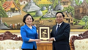 Minister of Home Affairs Pham Thi Thanh Tra presenting a souvenir to Lao Minister of Planning and Investment Khamchen Vongphosi.