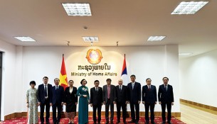 A group photo of Vietnamese Minister of Home Affairs Pham Thi Thanh Tra and Lao Minister of Home Affairs Thongchanh Manixay with members of the delegation.