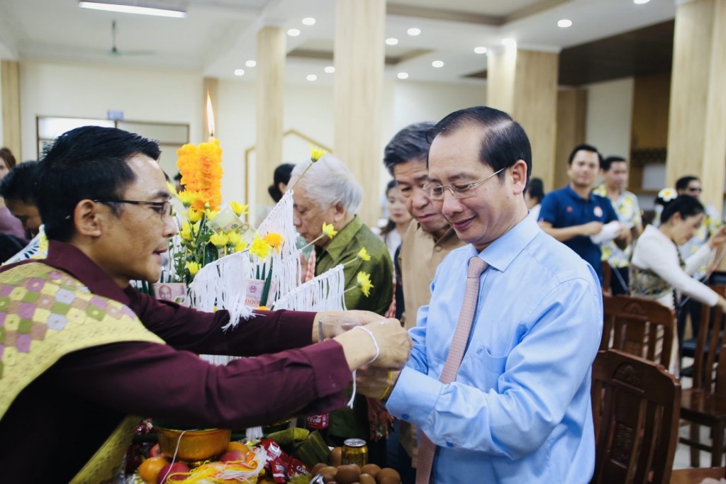 Assoc. Prof. Dr. Nguyen Ba Chien attending the Lao ritual of tying strings around wrists.