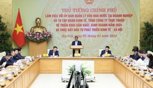 Prime Minister Pham Minh Chinh (standing) addresses the working session with the Commission for Management of State Capital at Enterprises (CMSC) and 19 groups and corporations under the commission's management on February 5.