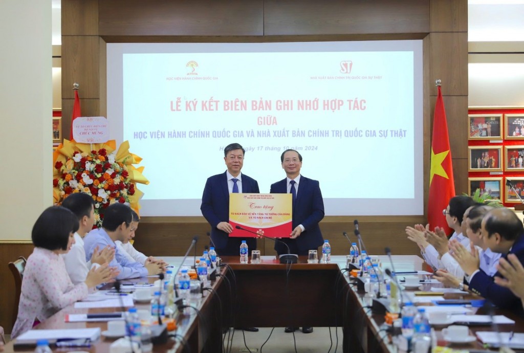 Assoc. Prof. Dr. Vu Trong Lam, representing the National Political Publishing House, presenting the "Bookshelf of Protecting the Ideological Foundation of the Party of Viet Nam" and the "Electronic Party Cell Bookshelf" to NAPA.