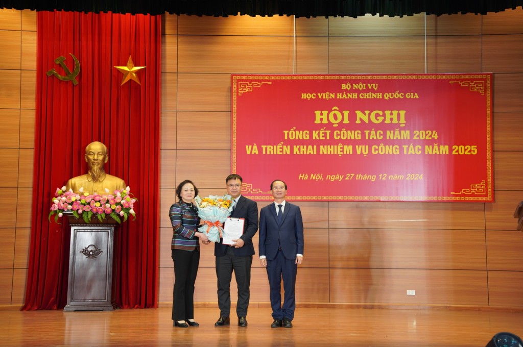 Minister Pham Thi Thanh Tra and NAPA President Nguyen Ba Chien jointly presented the decision to appoint the title of Professor and congratulated Prof. Dr. Nguyen Quoc Suu with flowers.