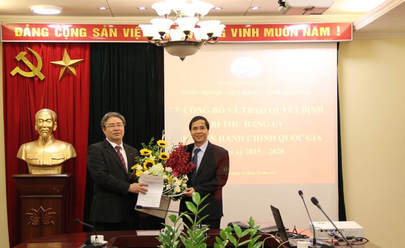 Đồng chí Triệu Văn Cường trao Quyết định và tặng hoa chúc mừng Tân Bí thư Đẳng ủy Học viện Hành chính Quốc gia Đặng Xuân Hoan
