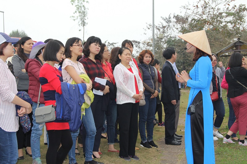Hướng dẫn viên du lịch giới thiệu với đoàn về Làng Văn hóa các dân tộc Việt Nam