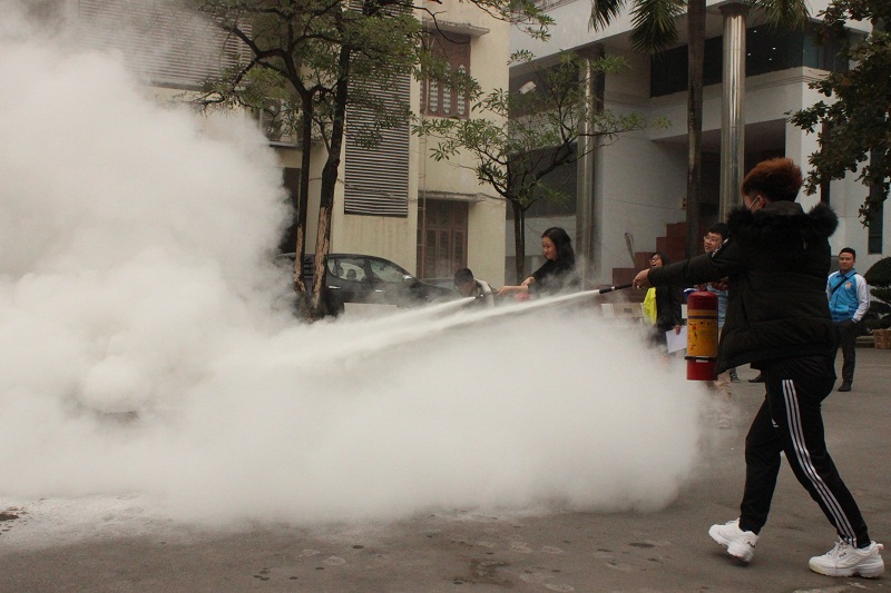 Các cán bộ, viên chức, người lao động và sinh viên Học viện thực hành sử dụng bình bột và bình CO2 dập tắt đám cháy