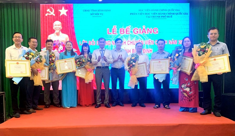 PGS.TS. Nguyễn Hoàng Hiển và đồng chí Lê Minh Tuấn trao giấy khen và hoa cho các học viên đạt thành tích cao trong học tập của 02 lớp