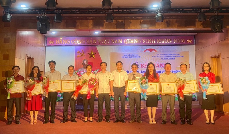 PGS.TS. Nguyễn Hoàng Hiển cùng đồng chí Nguyễn Đức Cường trao giấy khen và hoa cho các học viên đạt thành tích cao trong học tập
